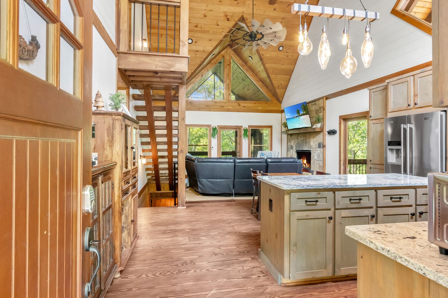 Soaring great room with timber staircase and prism windows